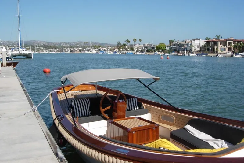 Slide: The Image of 2001 Wajer Captain's Launch 7m docked by a scenic waterfront with modern homes. - 10