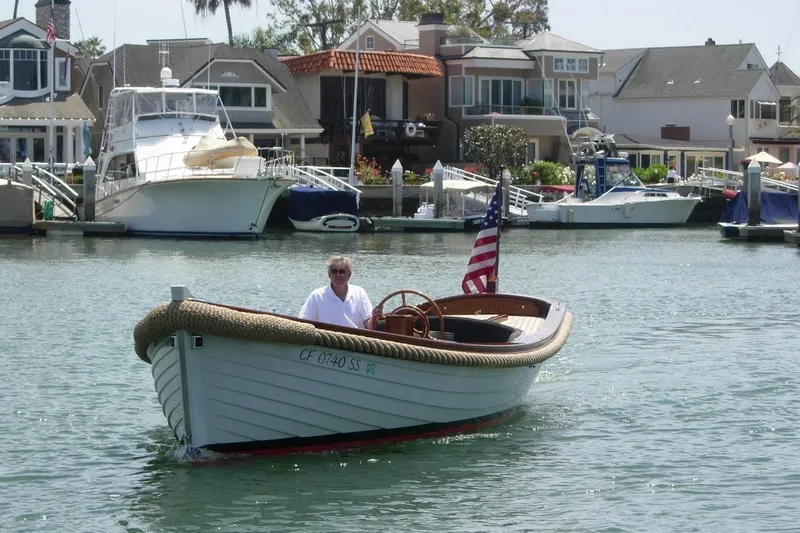 Slide: The Image of 2001 Wajer Captain's Launch 7m boat cruising in a marina with waterfront homes. - 3