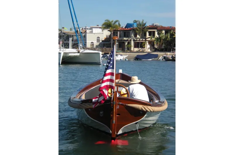 Slide: The Image of 2001 Wajer Captain's Launch 7m boat with American flag on calm water. - 9