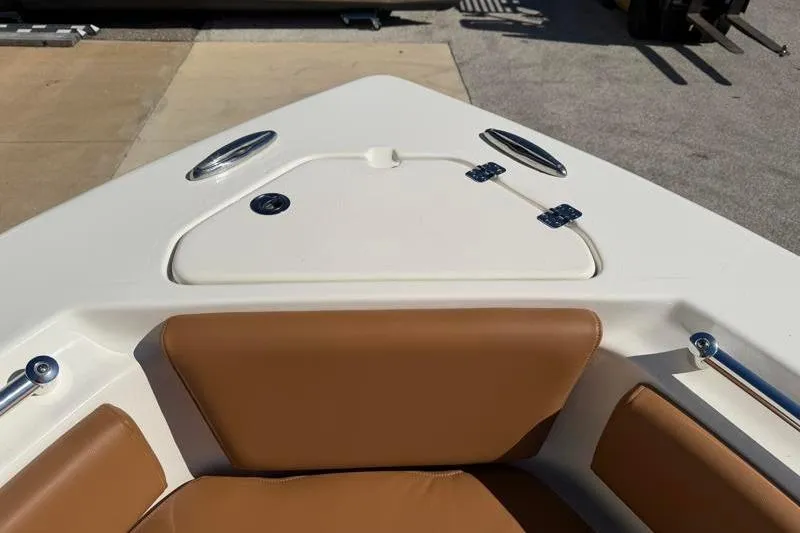 Slide: The Image of 2025 Key West 239 FS boat bow with tan seating and storage hatch. - 19