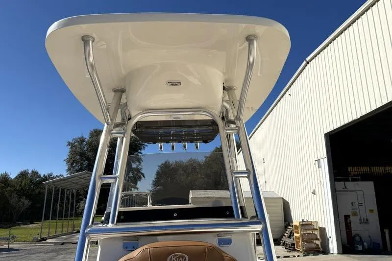 Slide: The Image of 2025 Key West 239 FS boat with T-top, parked near a warehouse. - 22