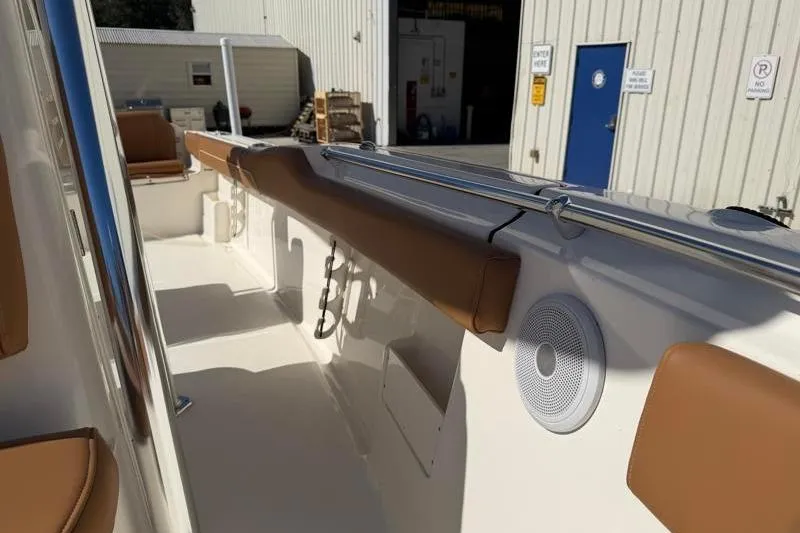 Slide: The Image of 2025 Key West 239 FS boat interior with tan seating and speaker. - 24