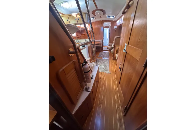 Slide: The Image of Interior of 2003 Catalina 470 sailboat with wooden flooring and cozy seating area. - 14