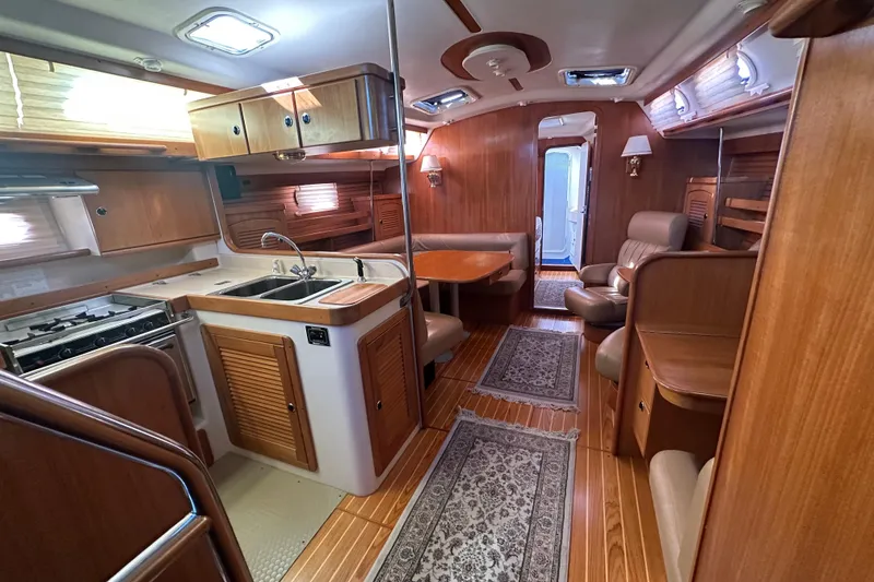 Slide: The Image of Interior of a 2003 Catalina 470 yacht with wood finish and cozy seating area. - 16