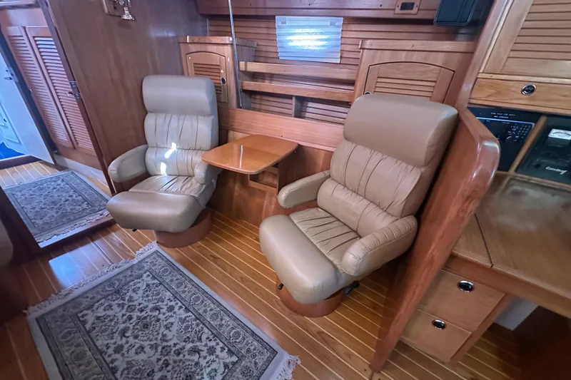 Slide: The Image of Luxurious interior of 2003 Catalina 470 yacht with leather chairs and wooden accents. - 21