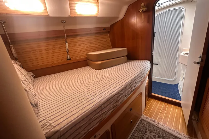 Slide: The Image of Cozy cabin interior of 2003 Catalina 470 sailboat with striped bedding and wooden accents. - 23