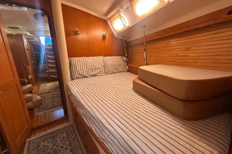 Slide: The Image of Cozy cabin interior of 2003 Catalina 470 sailboat with striped bedding and wooden accents. - 27