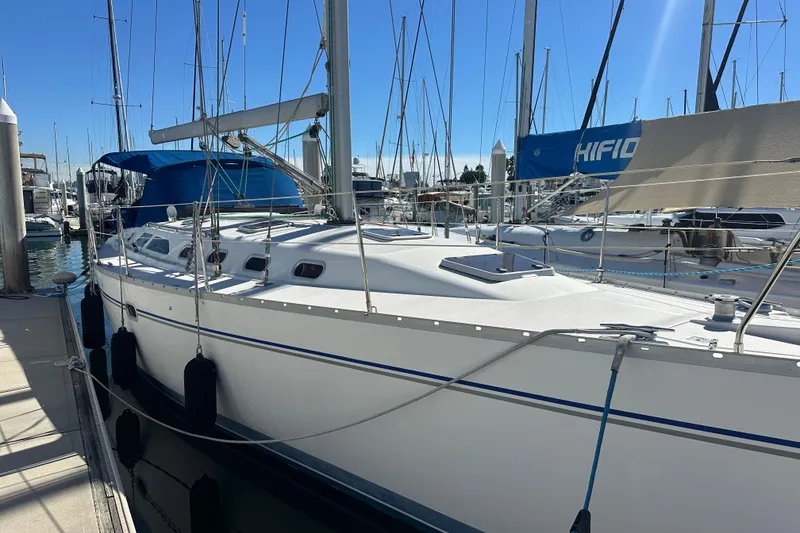 Slide: The Image of 2003 Catalina 470 sailboat docked at a marina under clear blue skies. - 3