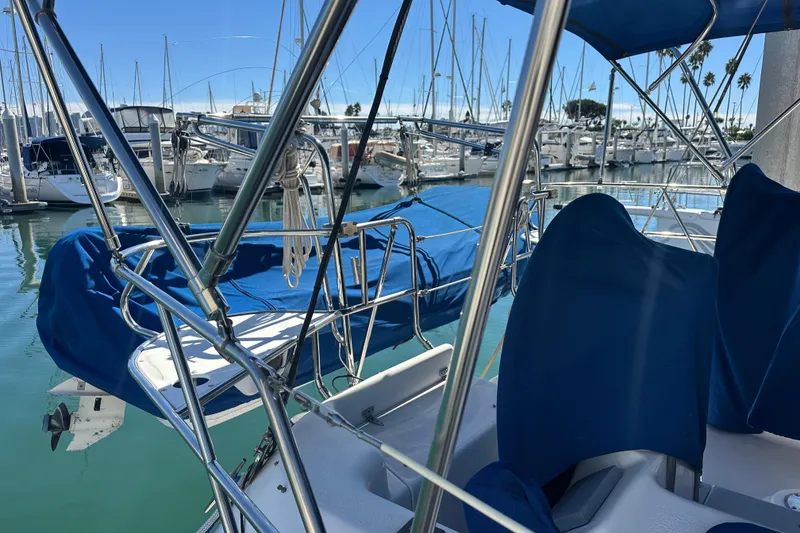 Slide: The Image of 2003 Catalina 470 sailboat docked in marina, featuring blue covers and stainless steel railings. - 4