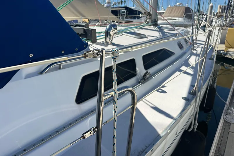 Slide: The Image of 2003 Catalina 470 sailboat docked, featuring sleek design and stainless steel railings. - 6