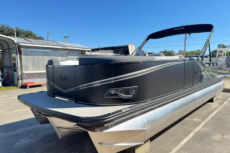 The Image of 2025 Avalon LSZ 2585 CRB pontoon boat with sleek black design, docked outdoors. - 1