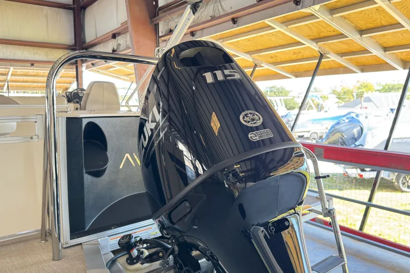 Slide: The Image of 2025 Avalon 2185 Rear Fish boat with Suzuki 115 outboard motor in a covered marina. - 5