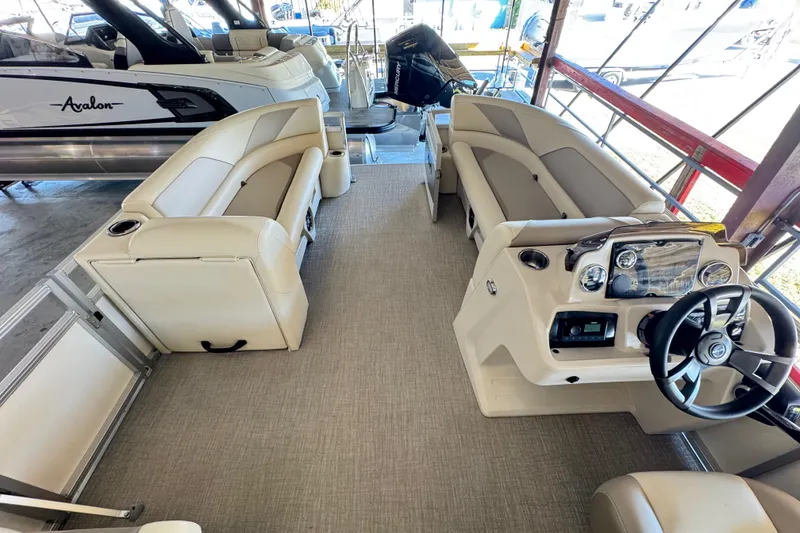 Slide: The Image of 2025 Avalon 2185 Rear Fish boat interior with beige seating and modern dashboard. - 8