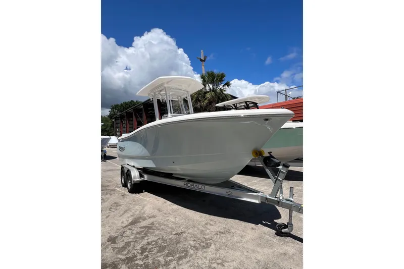 Slide: The Image of 2023 Robalo R230 Center Console boat on trailer under blue sky. - 4