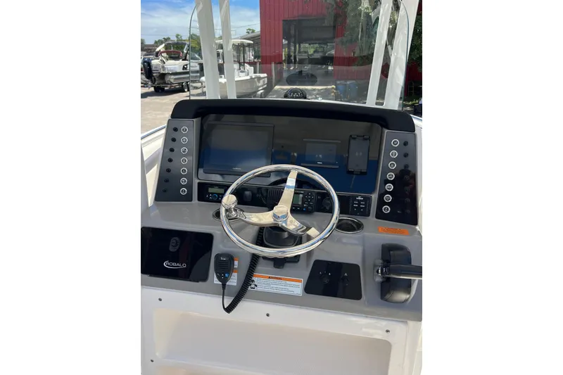 Slide: The Image of 2023 Robalo R230 Center Console boat dashboard with steering wheel and controls. - 8
