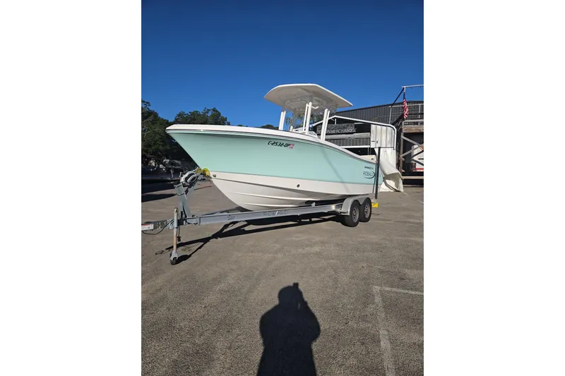 Slide: The Image of 2021 Robalo R230 Center Console boat on trailer, parked outdoors. - 2
