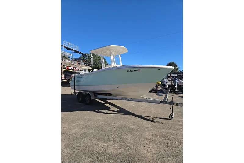 Slide: The Image of 2021 Robalo R230 Center Console boat on trailer under clear blue sky. - 3