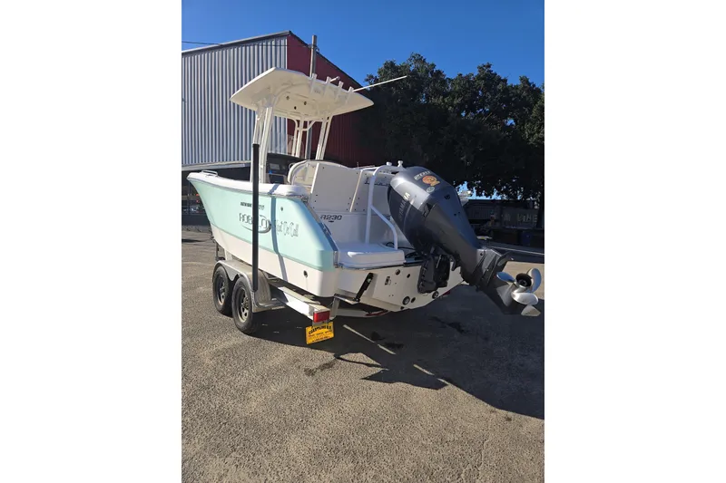 Slide: The Image of 2021 Robalo R230 Center Console boat on trailer, outdoor setting. - 5