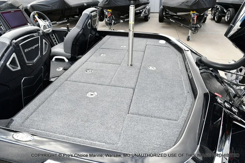 Slide: The Image of 2023 Ranger Z520R boat interior with carpeted deck and seating, displayed in a showroom. - 44