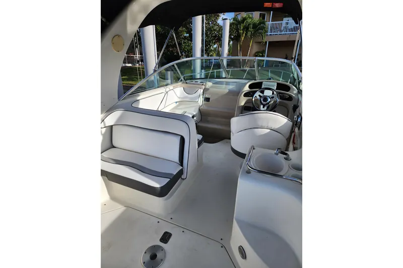 Slide: The Image of 2003 Sea Ray Sundancer 260 boat interior with white seating and steering console. - 10