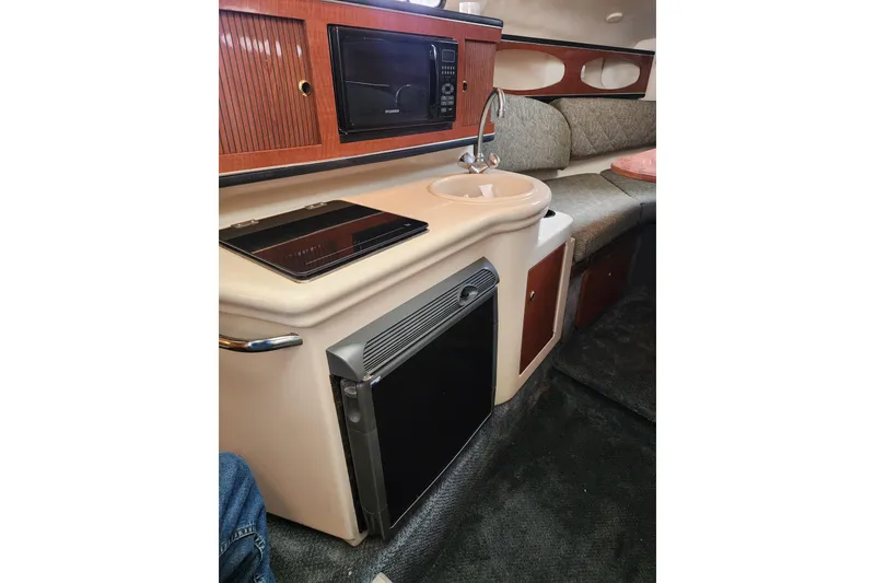 Slide: The Image of 2003 Sea Ray Sundancer 260 cabin interior with kitchenette, sink, and seating area. - 12
