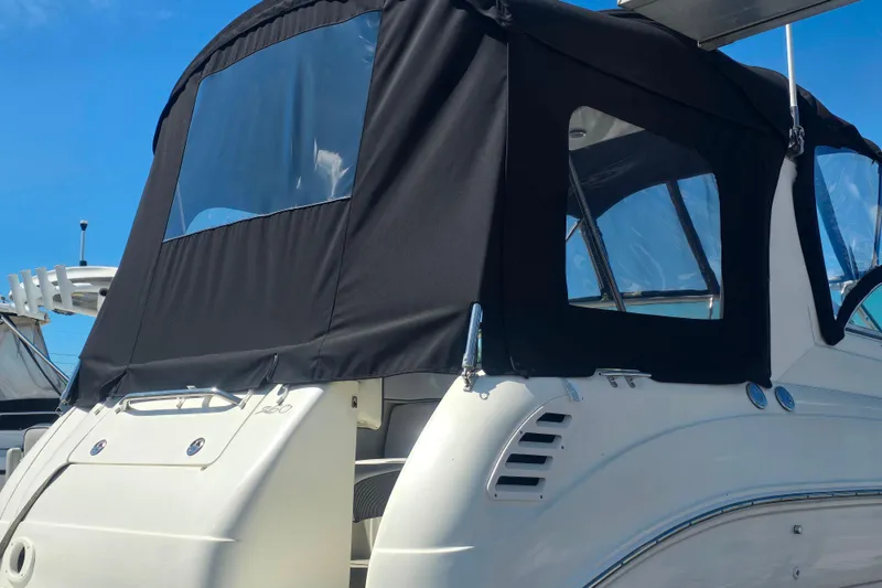 Slide: The Image of 2003 Sea Ray Sundancer 260 with black canvas cover under clear blue sky. - 18