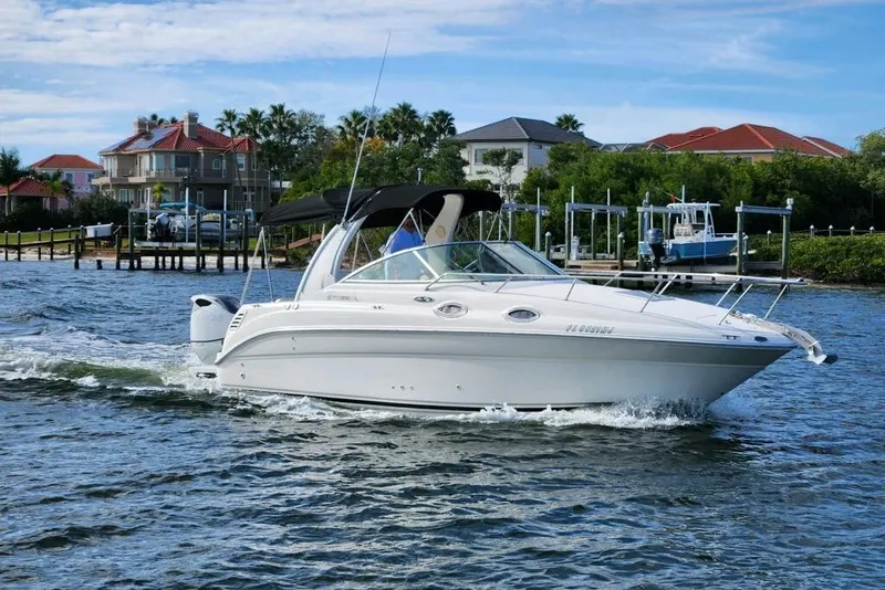 Slide: The Image of 2003 Sea Ray Sundancer 260 cruising on a scenic waterfront with luxury homes. - 5