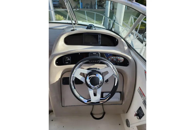 Slide: The Image of 2003 Sea Ray Sundancer 260 helm with steering wheel and dashboard controls. - 6