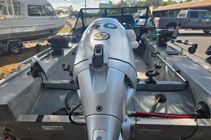 Slide: The Image of 1997 Westcoaster 17 boat with outboard motor, parked outdoors. - 3