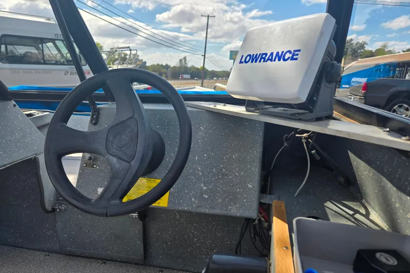 Slide: The Image of Interior of a 1997 Westcoaster 17 boat with steering wheel and Lowrance device. - 6