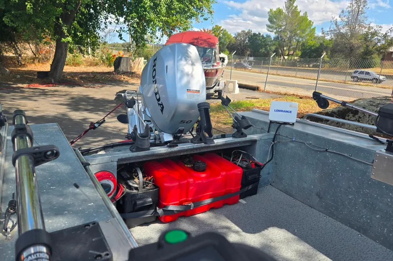 Slide: The Image of 1997 Westcoaster 17 boat with Honda outboard motor and Lowrance equipment, parked outdoors. - 7