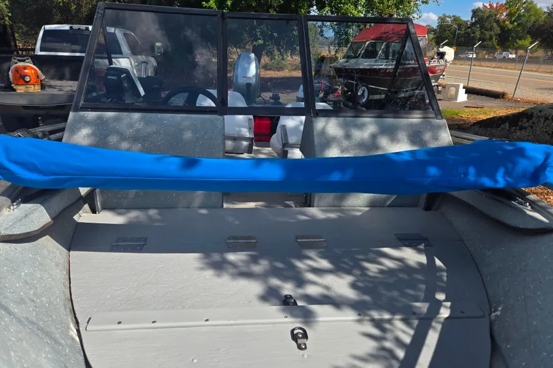 Slide: The Image of 1997 Westcoaster 17 boat with blue cover, parked outdoors. - 8