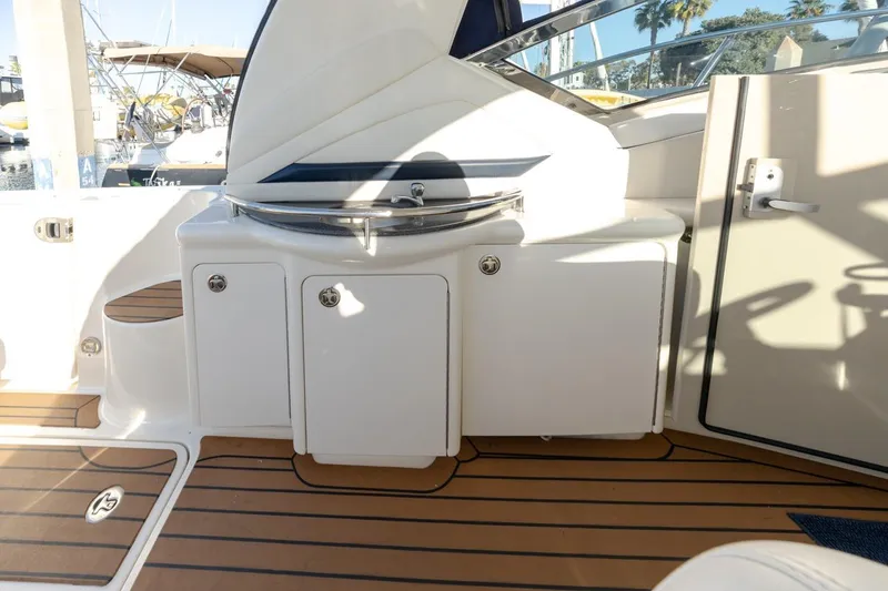 Slide: The Image of 2005 Sea Ray 390 Sundancer cockpit with white cabinetry and teak flooring. - 13