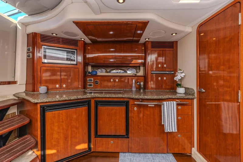 Slide: The Image of Luxurious 2005 Sea Ray 390 Sundancer yacht interior with elegant wood cabinetry and modern amenities. - 18