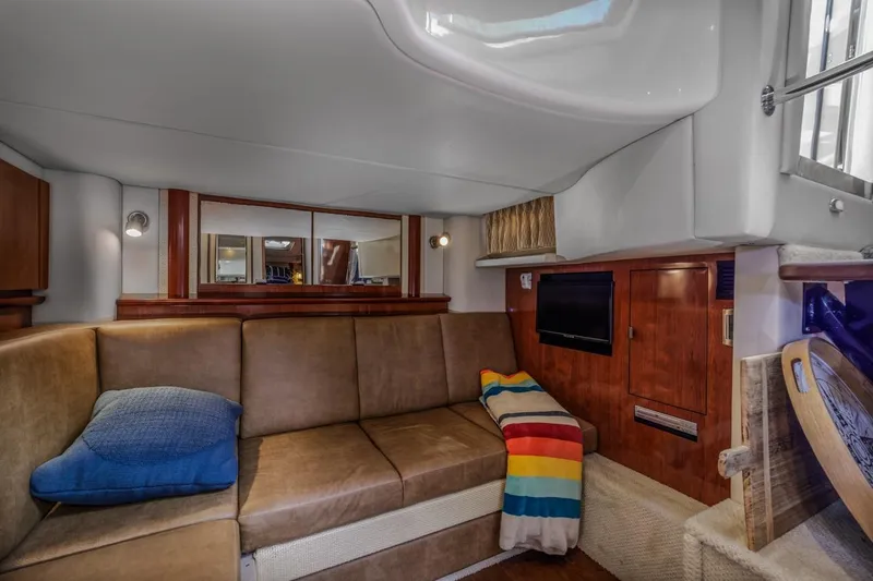 Slide: The Image of Interior of 2005 Sea Ray 390 Sundancer with cozy seating and colorful blanket. - 24