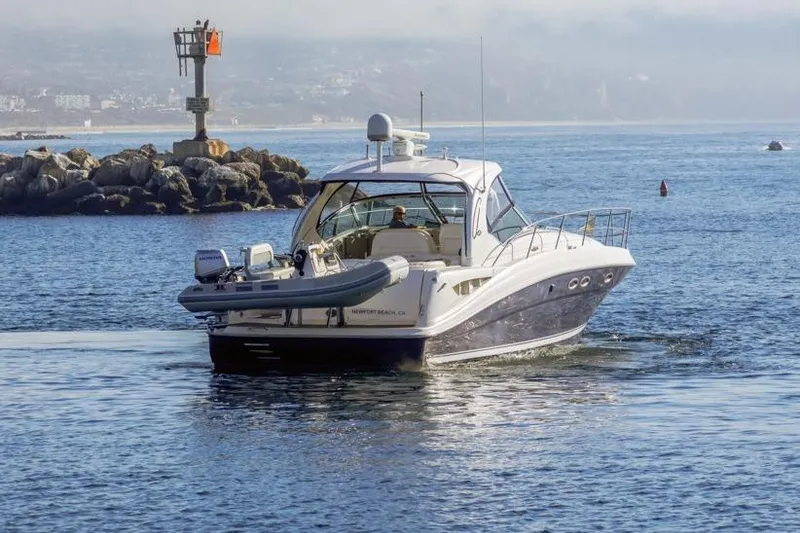 Slide: The Image of 2005 Sea Ray 390 Sundancer yacht cruising near rocky shoreline. - 4