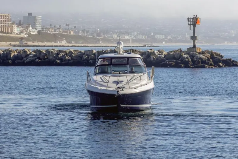 Slide: The Image of 2005 Sea Ray 390 Sundancer yacht cruising near rocky shoreline. - 5