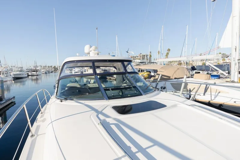 Slide: The Image of 2005 Sea Ray 390 Sundancer yacht docked at a marina under clear blue skies. - 6