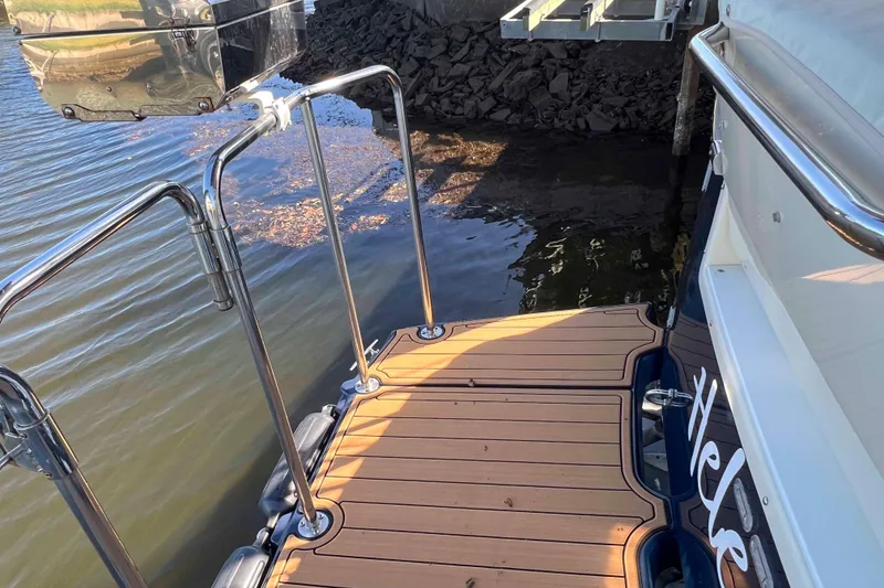 Slide: The Image of 2012 Cutwater 26 boat with wooden deck and stainless steel railings by the water. - 10