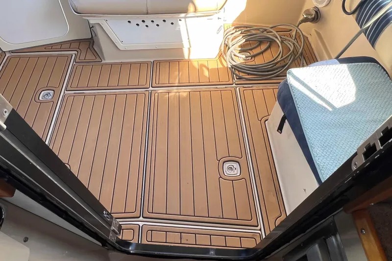 Slide: The Image of 2012 Cutwater 26 boat interior with teak flooring and coiled rope. - 11