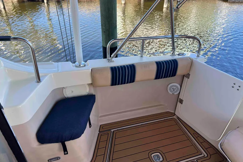 Slide: The Image of 2012 Cutwater 26 boat interior with cushioned seating and wood-patterned flooring. - 12