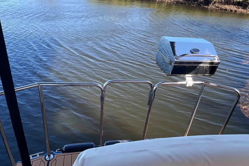 Slide: The Image of 2012 Cutwater 26 boat with a mounted grill on the deck, overlooking calm water. - 14