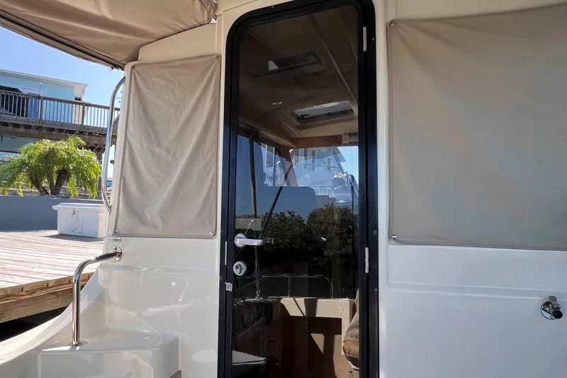 Slide: The Image of 2012 Cutwater 26 boat entrance with glass door and covered windows. - 15