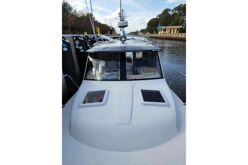 Slide: The Image of 2012 Cutwater 26 boat docked, featuring a sleek cabin and dual hatches. - 16
