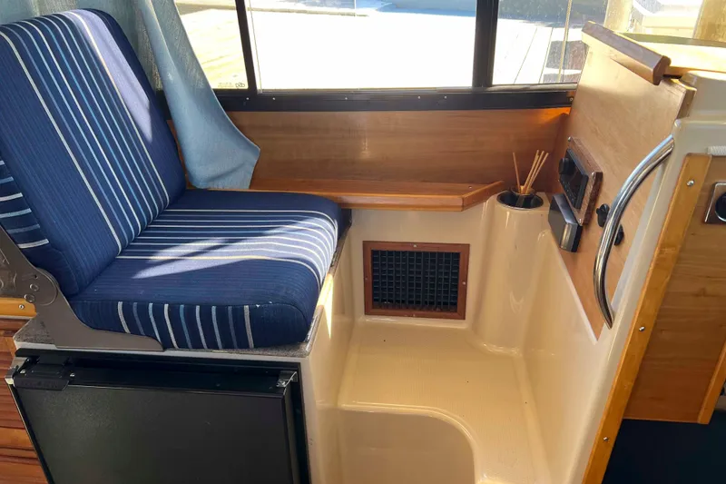 Slide: The Image of Interior of 2012 Cutwater 26 boat with blue striped seating and wooden accents. - 20