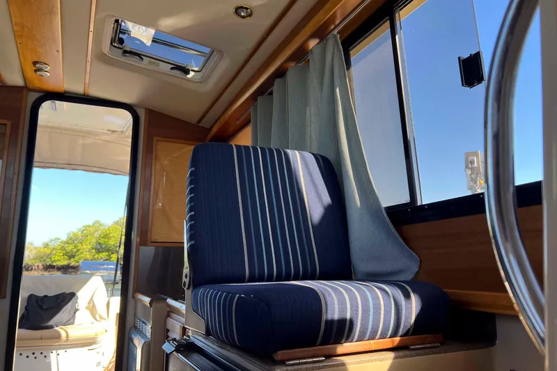 Slide: The Image of Interior of 2012 Cutwater 26 boat with striped seating and window view. - 21