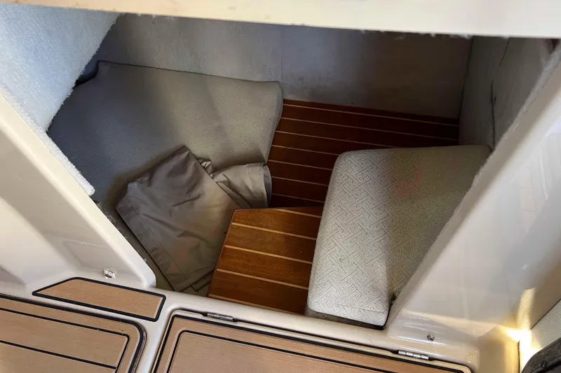 Slide: The Image of Interior cabin of a 2012 Cutwater 26 boat with wooden flooring and cushions. - 23