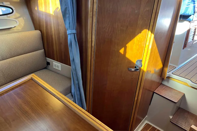 Slide: The Image of Interior of a 2012 Cutwater 26 boat with wood paneling and seating area. - 28