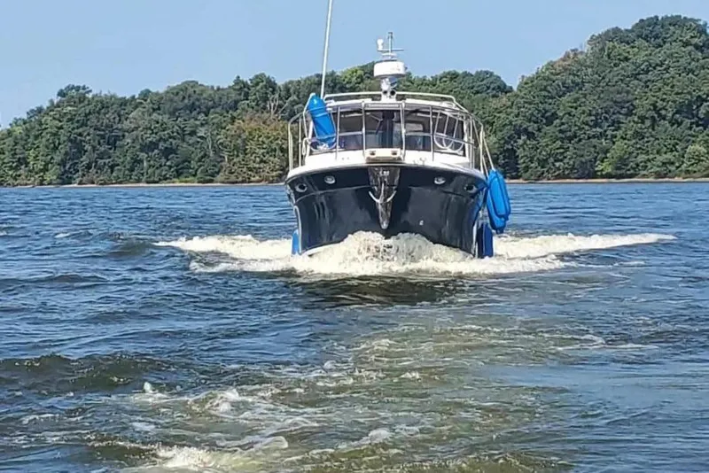 Slide: The Image of 2012 Cutwater 26 boat cruising on a lake with forested shoreline. - 3
