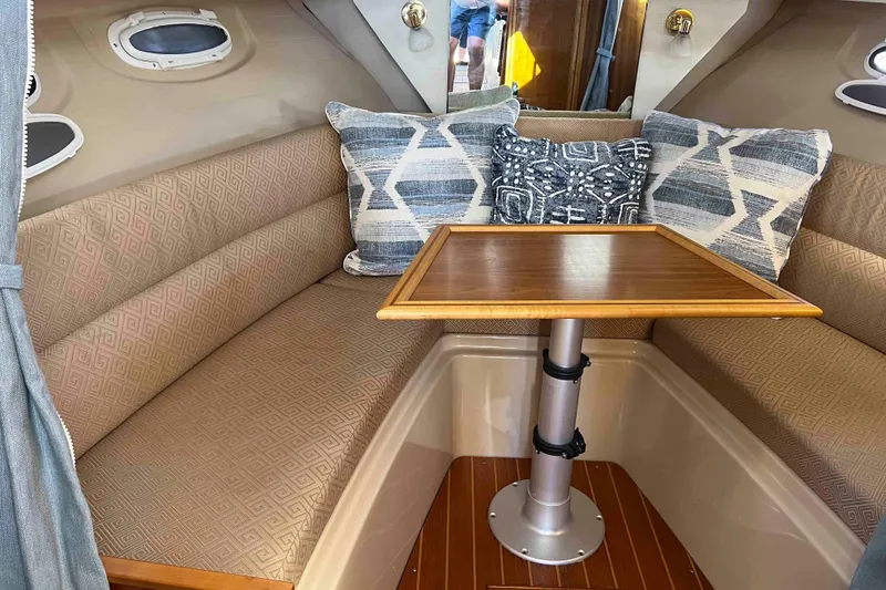 Slide: The Image of Cozy interior of 2012 Cutwater 26 boat with cushioned seating and wooden table. - 30